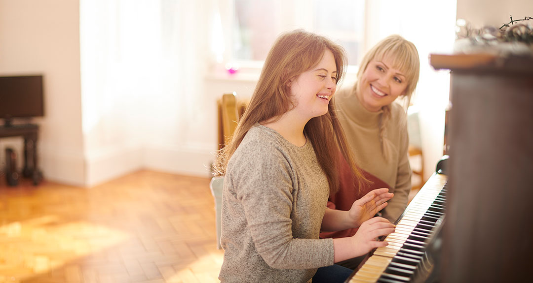a piano teacher helping a student play the piano